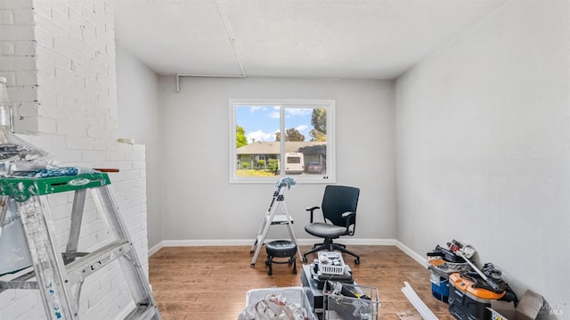 exercise room featuring baseboards and wood finished floors