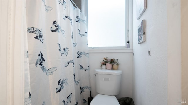 bathroom featuring toilet and a shower with shower curtain