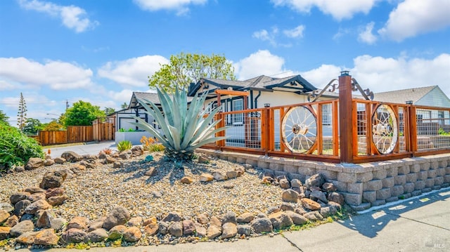 view of front of house featuring fence and concrete driveway