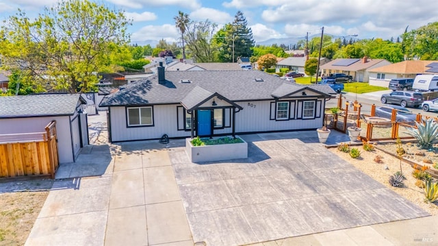 single story home featuring fence, a shingled roof, and a residential view
