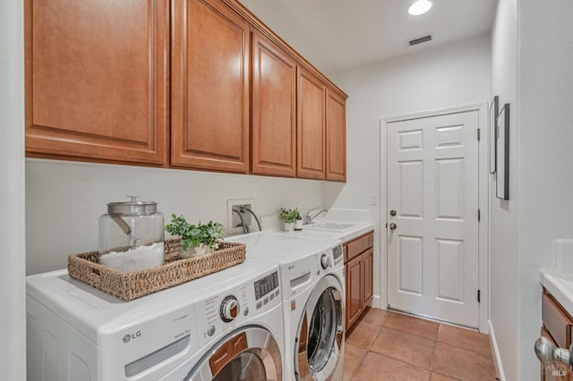clothes washing area with visible vents, light tile patterned flooring, a sink, cabinet space, and independent washer and dryer