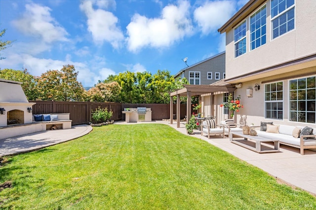 view of yard with an outdoor living space with a fireplace, a patio area, exterior kitchen, and fence