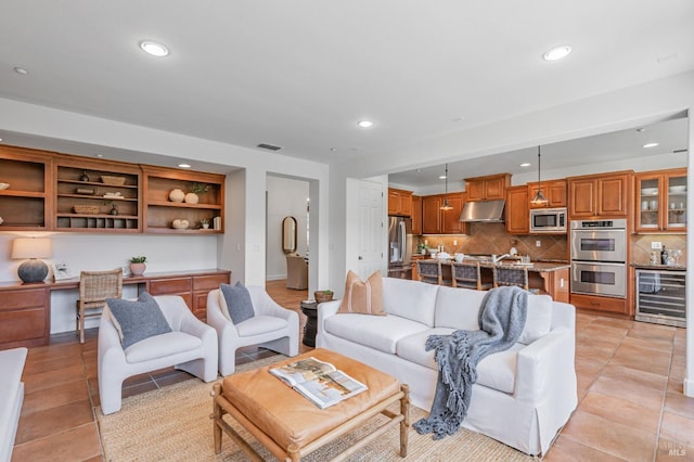 living room with wine cooler, light tile patterned flooring, recessed lighting, and built in study area