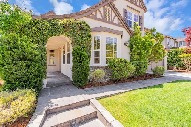 exterior space with stucco siding and a front lawn