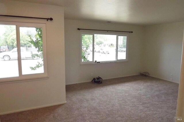 carpeted empty room with baseboards