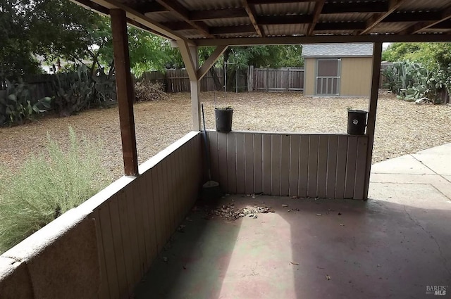 view of patio / terrace with an outdoor structure, a storage unit, and a fenced backyard