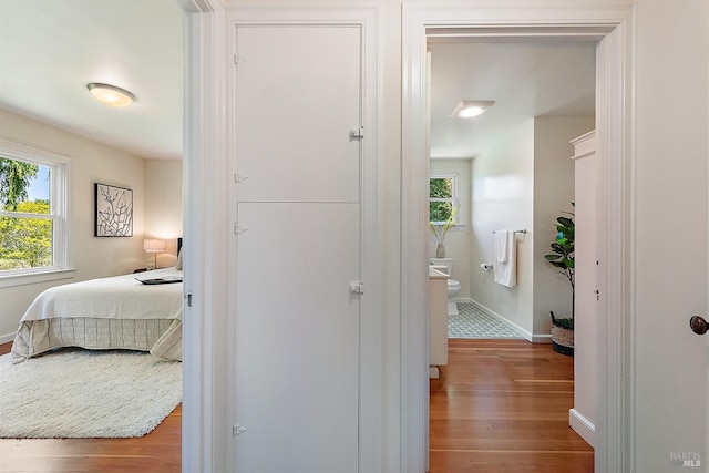 hallway with wood-type flooring and baseboards