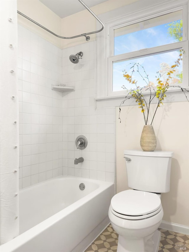 bathroom featuring tile patterned floors, shower / bath combo with shower curtain, and toilet