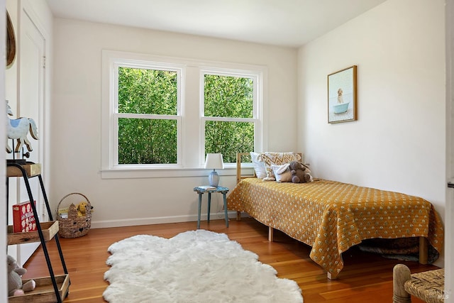 bedroom featuring baseboards and wood finished floors