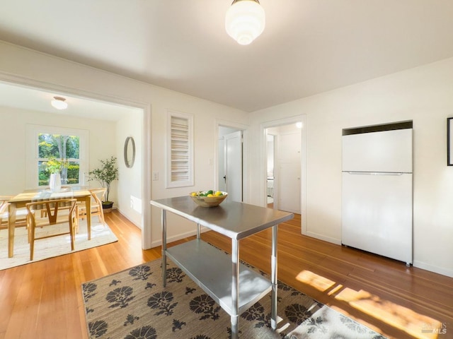dining area featuring light wood-style floors and baseboards
