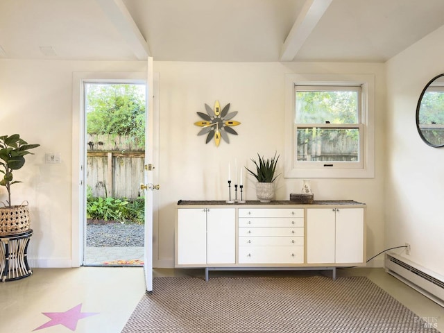 doorway with a baseboard heating unit and beamed ceiling