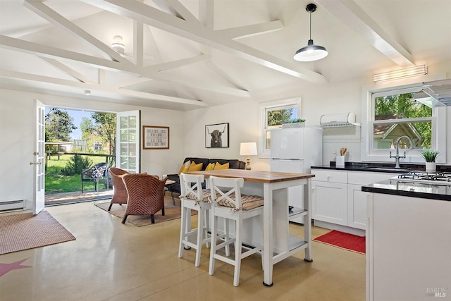 kitchen featuring beam ceiling, white cabinetry, a sink, freestanding refrigerator, and butcher block countertops