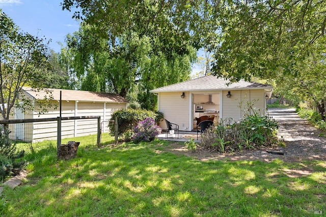 view of yard featuring fence and an outbuilding
