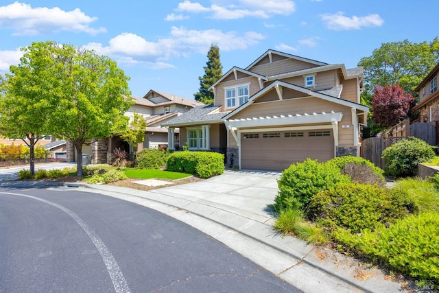craftsman inspired home with a garage, fence, driveway, and stone siding