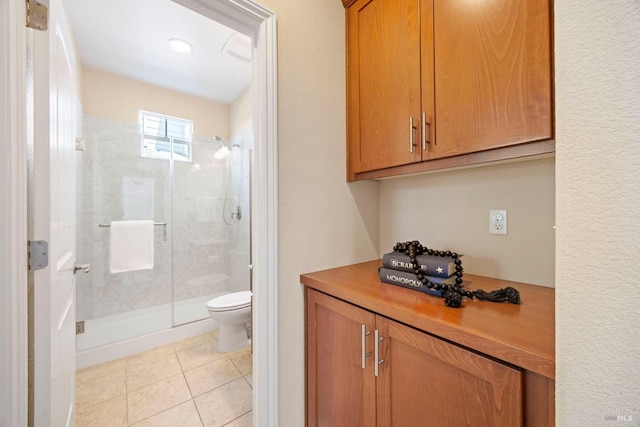 full bathroom with a shower stall, toilet, and tile patterned flooring
