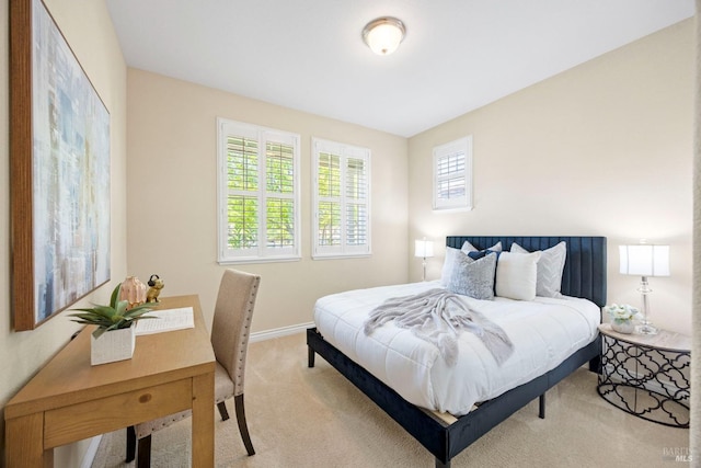 bedroom with baseboards and light carpet