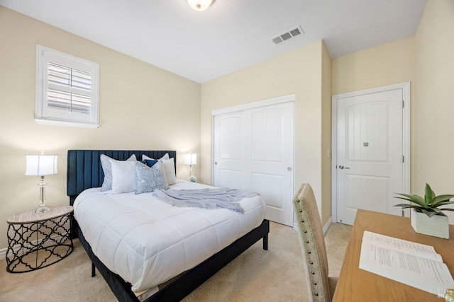bedroom featuring visible vents, a closet, baseboards, and light carpet