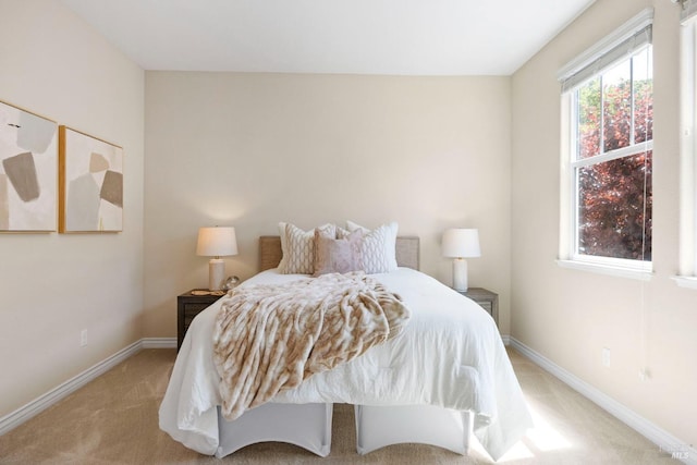 bedroom with light colored carpet and baseboards