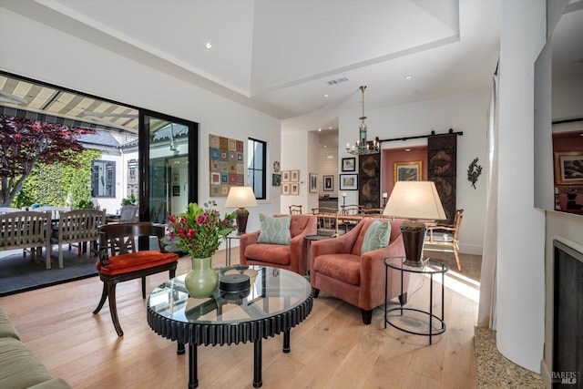 living area with recessed lighting, a notable chandelier, light wood-style flooring, and a fireplace