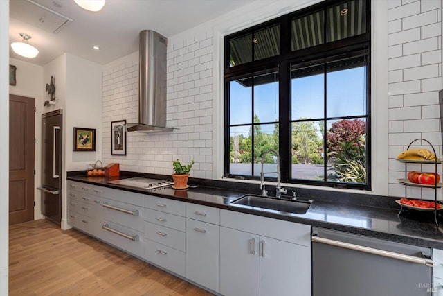 kitchen featuring a sink, ventilation hood, high quality fridge, stainless steel dishwasher, and dark countertops