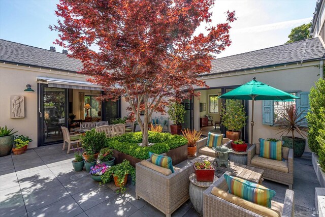 exterior space featuring stucco siding, a patio, and an outdoor hangout area