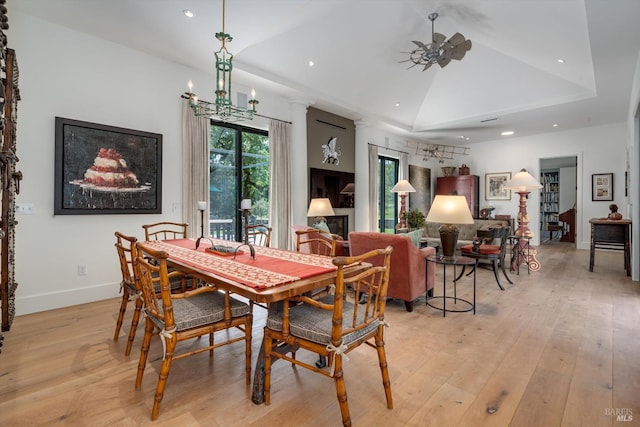 dining area with recessed lighting, a raised ceiling, light wood-type flooring, vaulted ceiling, and baseboards
