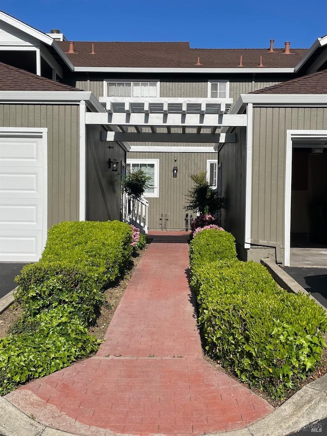 doorway to property with a shingled roof