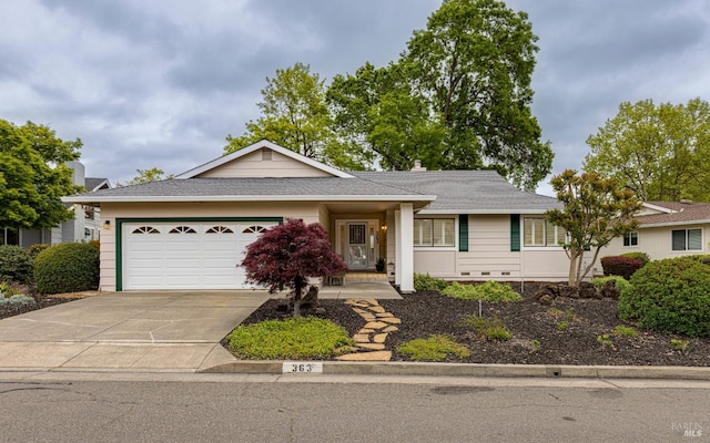 ranch-style house with concrete driveway, a garage, and roof with shingles
