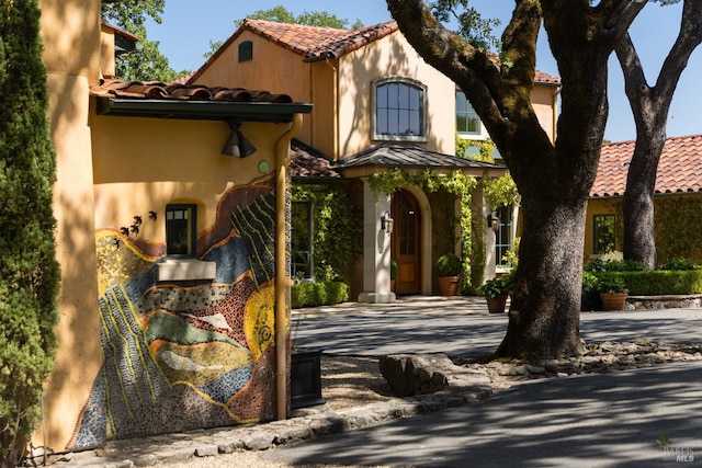 mediterranean / spanish home with stucco siding and a tile roof