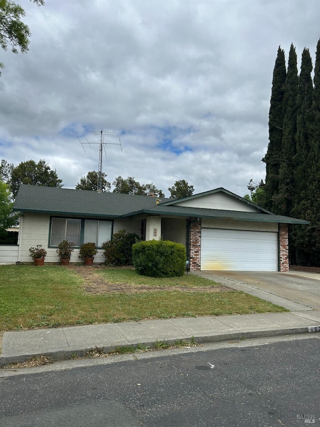 ranch-style home featuring a garage, brick siding, driveway, and a front yard