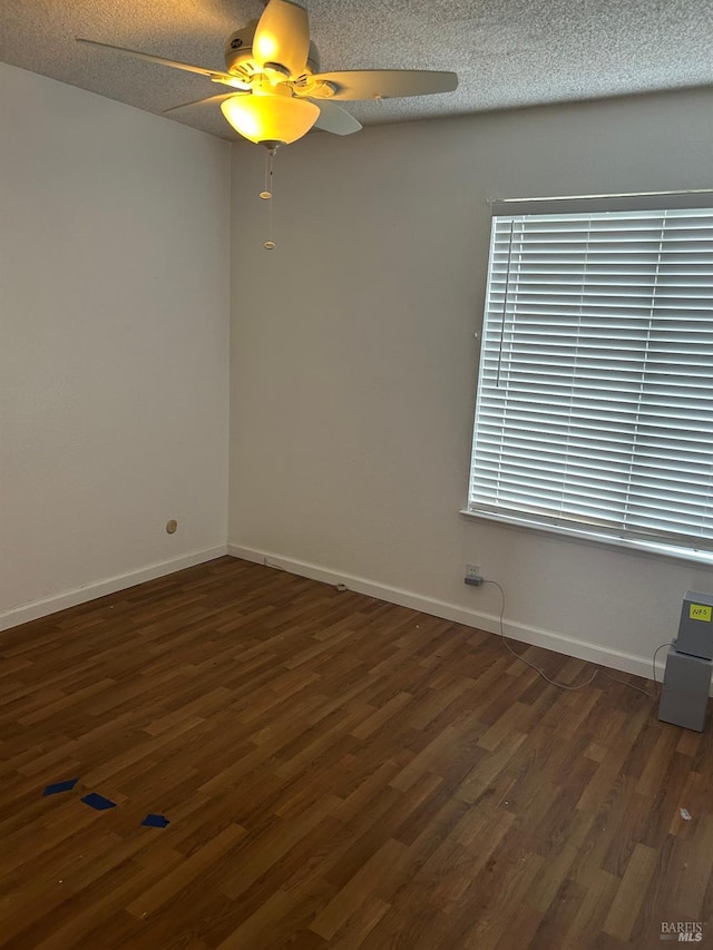 empty room featuring baseboards, wood finished floors, and a ceiling fan