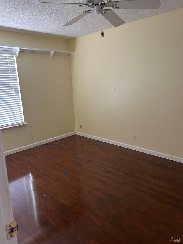 spare room with baseboards, a ceiling fan, a textured ceiling, and wood-type flooring