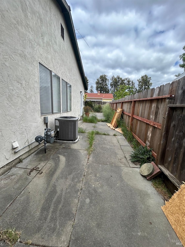 view of patio with cooling unit and a fenced backyard