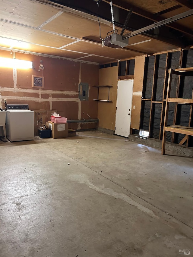 garage featuring electric panel, a garage door opener, and washer / clothes dryer