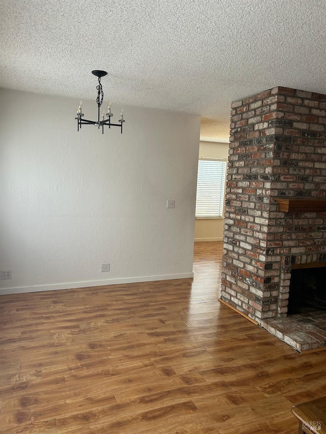 unfurnished dining area with a chandelier, baseboards, and a textured ceiling