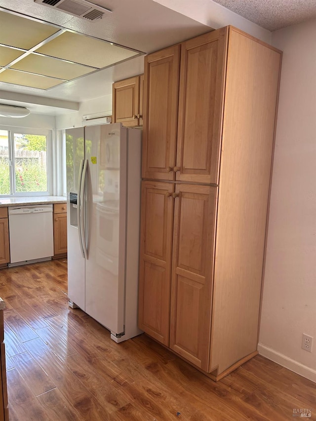 kitchen featuring wood finished floors, visible vents, white appliances, and light countertops