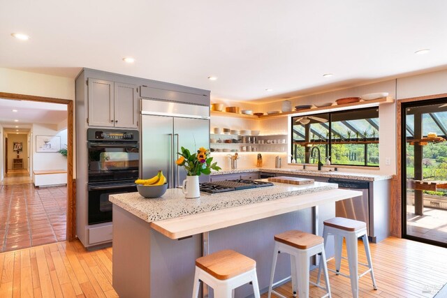 2200 Mcnab Ranch Rd, Ukiah, CA 95482 - kitchen featuring a breakfast bar area, light wood-style flooring, a sink, appliances with stainless steel finishes, and a kitchen island