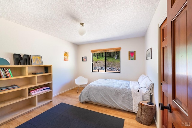 2200 Mcnab Ranch Rd, Ukiah, CA 95482 - bedroom featuring a textured ceiling, light wood finished floors, and baseboards