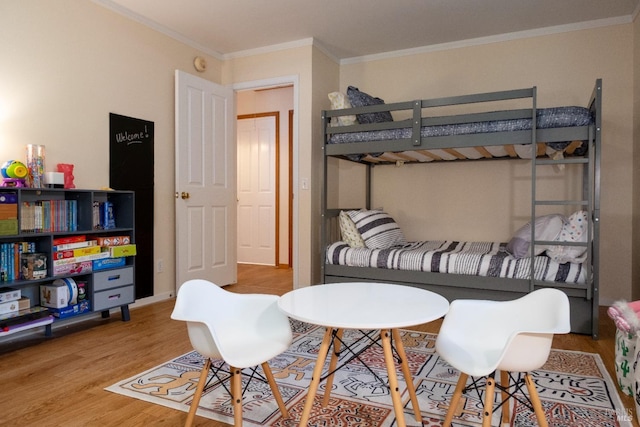 bedroom with wood finished floors and ornamental molding