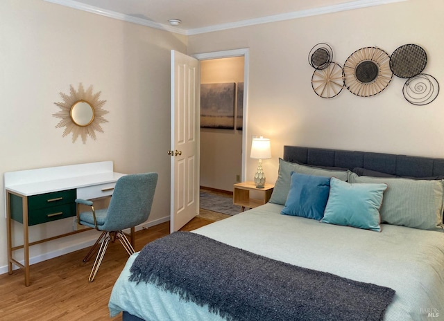 bedroom featuring wood finished floors, crown molding, and baseboards