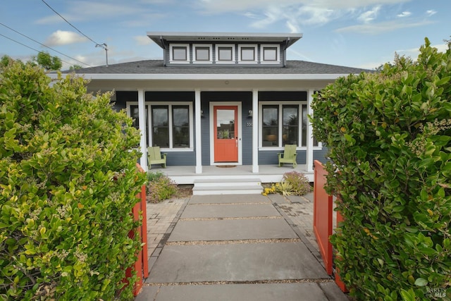 view of front of property with covered porch and roof with shingles