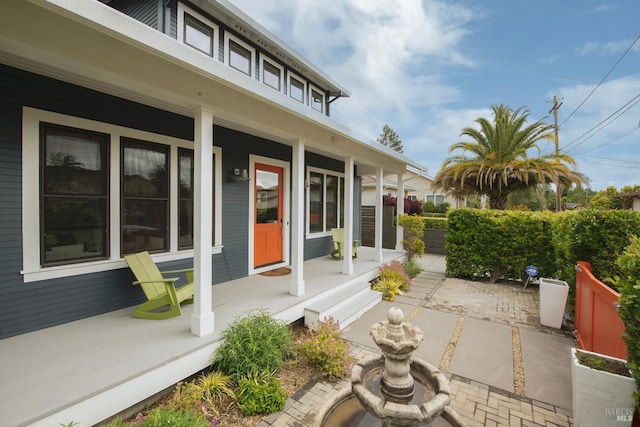 view of exterior entry featuring covered porch