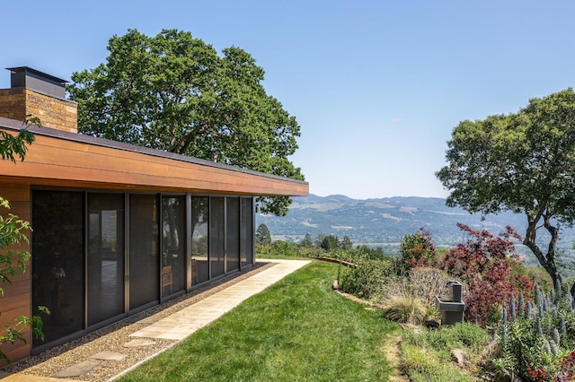 view of yard with a mountain view and a sunroom