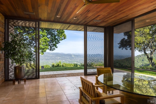 sunroom with wood ceiling, a wall of windows, tile patterned floors, and plenty of natural light