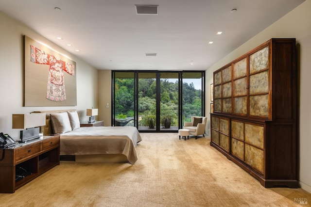 bedroom with recessed lighting, floor to ceiling windows, and light carpet