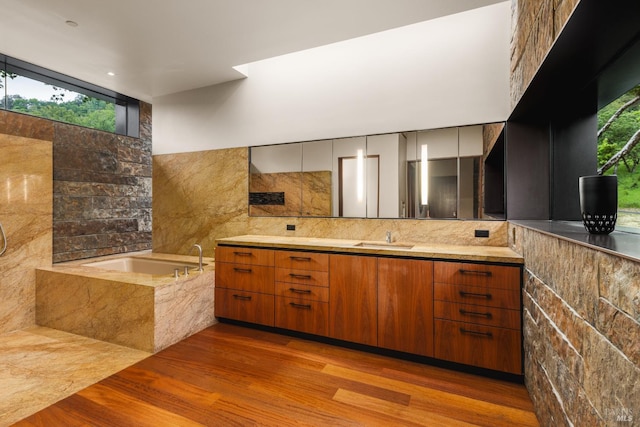 full bath with wood finished floors, backsplash, a bath, and vanity
