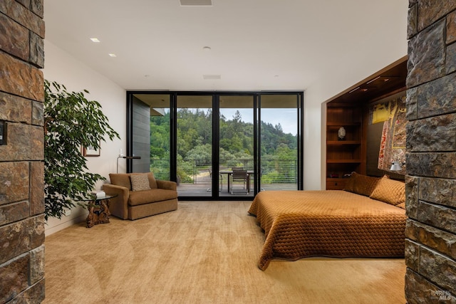 bedroom featuring access to exterior, floor to ceiling windows, and carpet floors