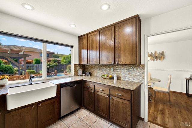 kitchen with recessed lighting, stainless steel dishwasher, decorative backsplash, and a sink