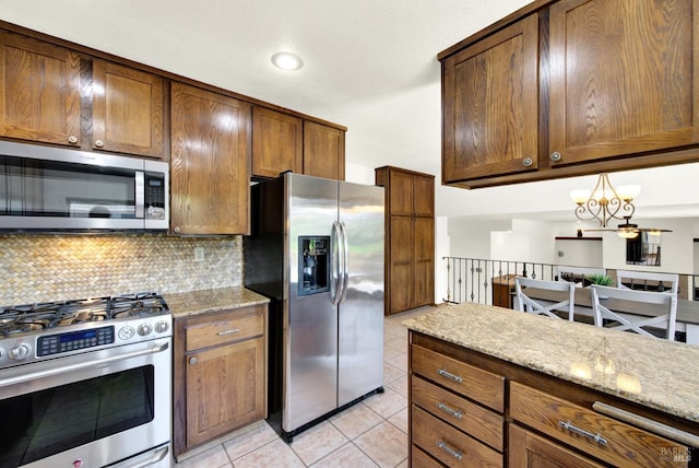 3237 Arroyo Dr, Fairfield, CA 94533 - kitchen featuring stainless steel appliances, light tile patterned floors, decorative backsplash, and light stone countertops