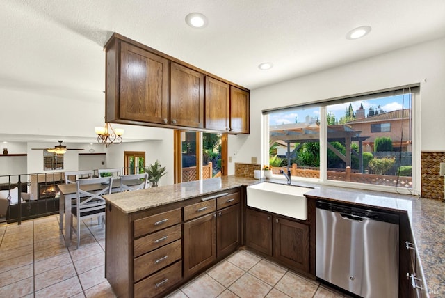 kitchen with plenty of natural light, a peninsula, dishwasher, and a sink